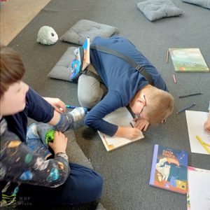 dzieci siedzą na podłodze i rysują