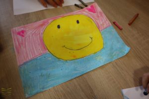 rysunek - uśmiechnięte słoneczko na kolorowym tle