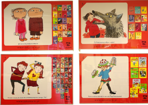 Na zdjęciu widać cztery plansze wystawowe z Wystawy-zabawy wydawnictwa Zakamarki. Na planszach umieszczono grafiki z książek z serii "Albert", "Biuro detektywistyczne Lassego i Mai", "Nusia" oraz "Pippi Pończoszanka". Grafiki mają czerwone tło i przedstawiają też wszystkie książki z danej serii.