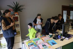 Czytelnicy oglądają stanowisko bibliotekarskie w dziale dziecięcym