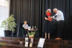 Na końcu spotkania, pan wręcza kwiaty autorce.