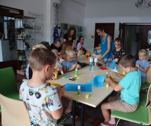 zdjęcie grupowe - dzieci siedzą przy stolikach