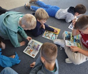 dzieci pochylone nad komiksami