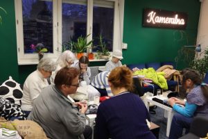 Uczestniczki szydełkują w salce kameralnej